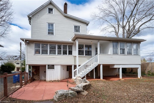 back of property featuring stairs, a patio, a chimney, and fence