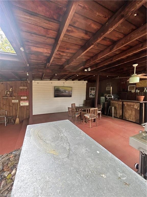 interior space with wooden ceiling, beamed ceiling, and wood walls