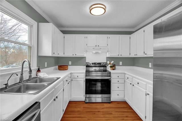 kitchen with a sink, stainless steel appliances, white cabinets, under cabinet range hood, and light wood-type flooring