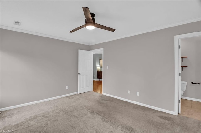 unfurnished bedroom featuring crown molding, carpet flooring, baseboards, and visible vents