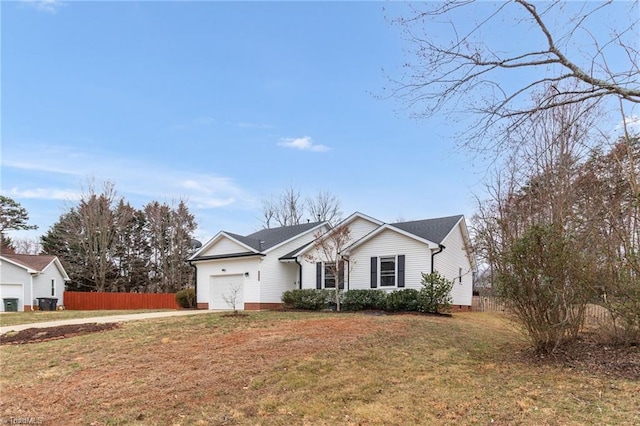 ranch-style home featuring a front yard, an attached garage, and fence