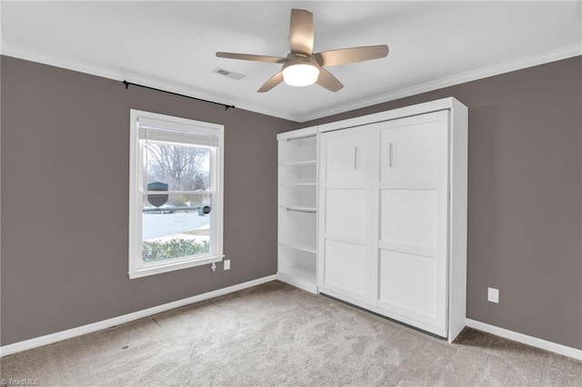 unfurnished bedroom featuring crown molding, baseboards, and carpet floors