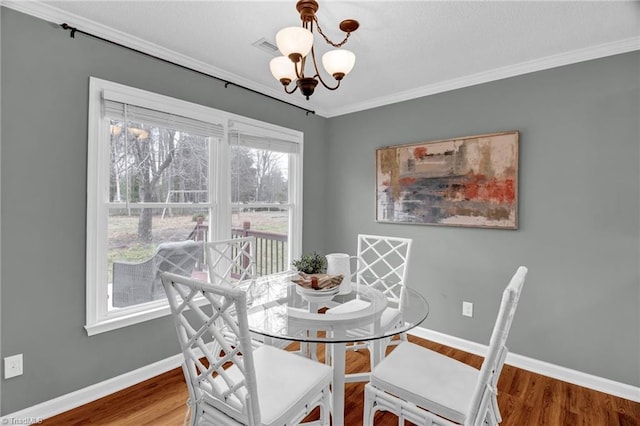 dining room with wood finished floors, baseboards, and a chandelier