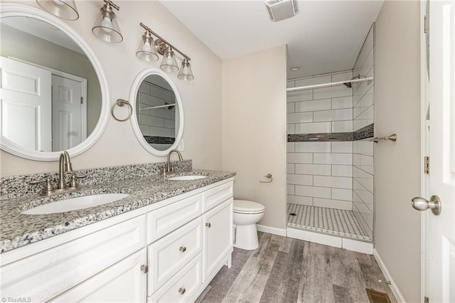 bathroom featuring visible vents, toilet, wood finished floors, and a sink