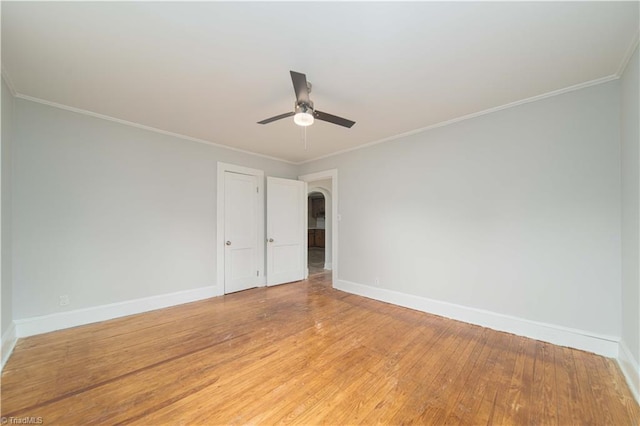 4065 Leo St, Winston-Salem, NC 27105 - empty room featuring baseboards, a ceiling fan, light wood-style flooring, arched walkways, and crown molding
