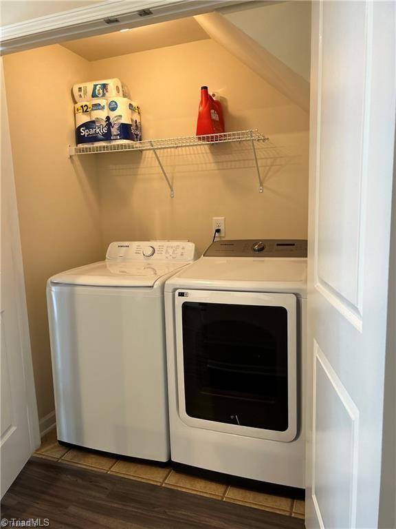 washroom featuring wood finished floors, washing machine and dryer, and laundry area