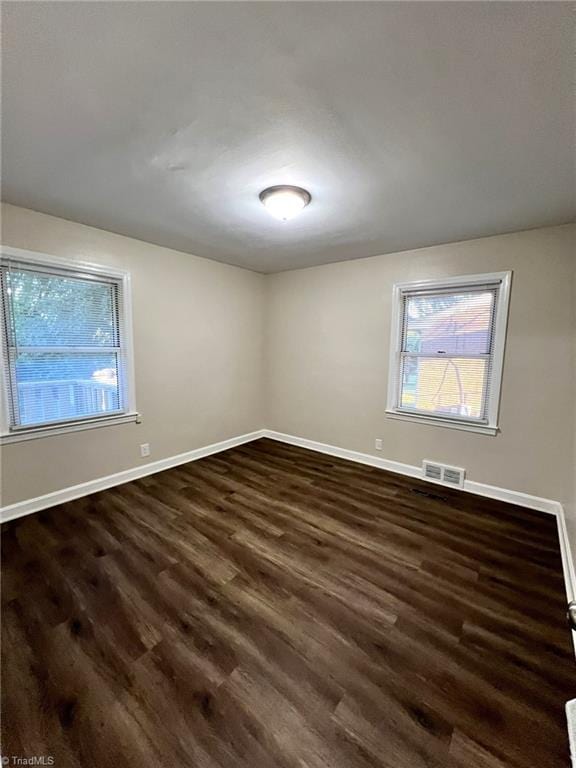 unfurnished room with dark hardwood / wood-style floors