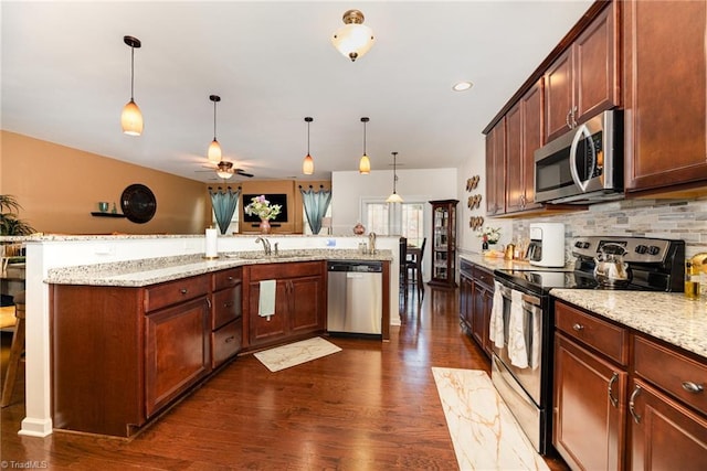 2711 Chari Park Ln, Walkertown, NC 27051 - kitchen featuring appliances with stainless steel finishes, dark wood-style flooring, tasteful backsplash, a ceiling fan, and hanging light fixtures