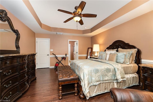 2711 Chari Park Ln, Walkertown, NC 27051 - bedroom with a tray ceiling, dark wood finished floors, baseboards, ensuite bathroom, and a ceiling fan
