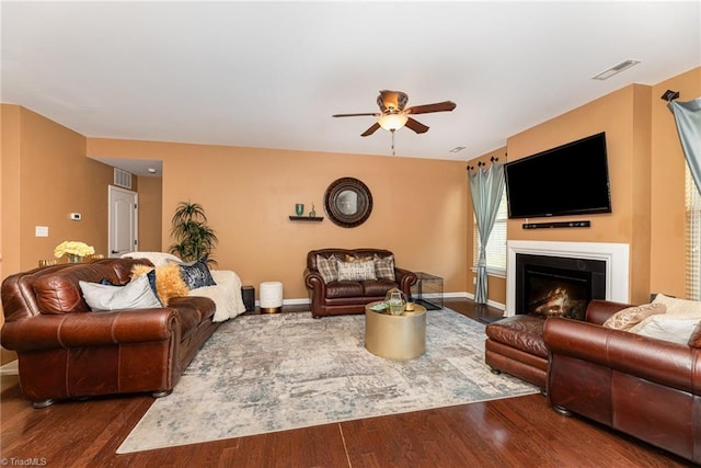 2711 Chari Park Ln, Walkertown, NC 27051 - living area featuring a ceiling fan, dark wood finished floors, a lit fireplace, and baseboards