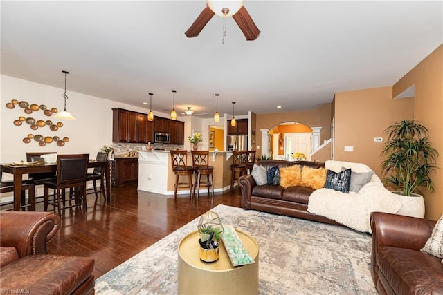 2711 Chari Park Ln, Walkertown, NC 27051 - living area featuring a ceiling fan, arched walkways, dark wood-type flooring, and baseboards