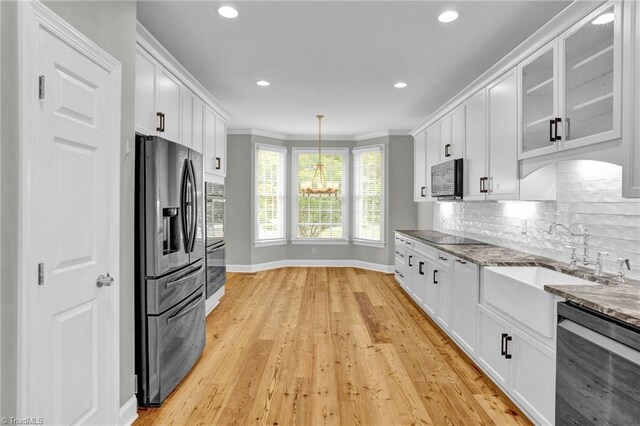 unfurnished living room with ceiling fan with notable chandelier, light hardwood / wood-style floors, a high end fireplace, and high vaulted ceiling