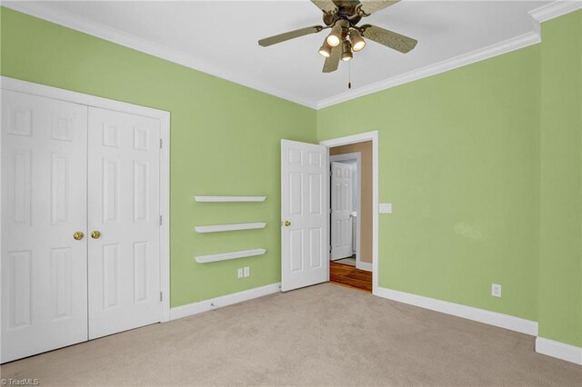 carpeted empty room featuring ornamental molding and ceiling fan