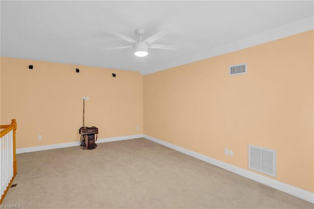 unfurnished room featuring ceiling fan, light colored carpet, a wealth of natural light, and a raised ceiling