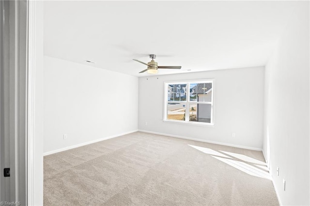 spare room featuring light carpet and ceiling fan