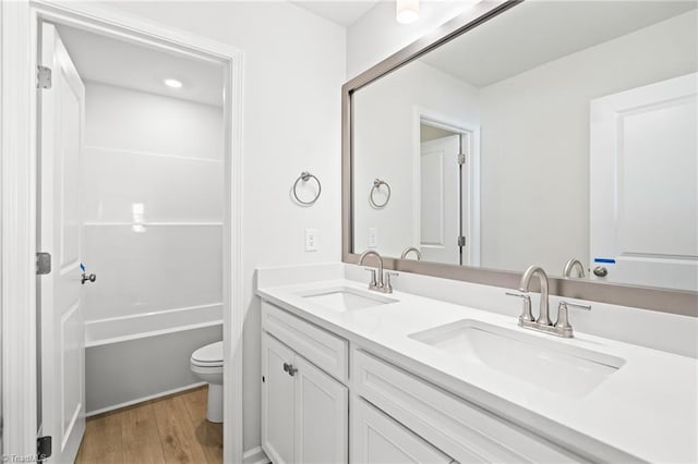 bathroom featuring wood-type flooring, vanity, and toilet