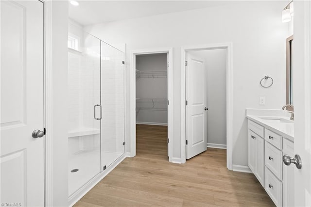 bathroom featuring hardwood / wood-style flooring, vanity, and an enclosed shower