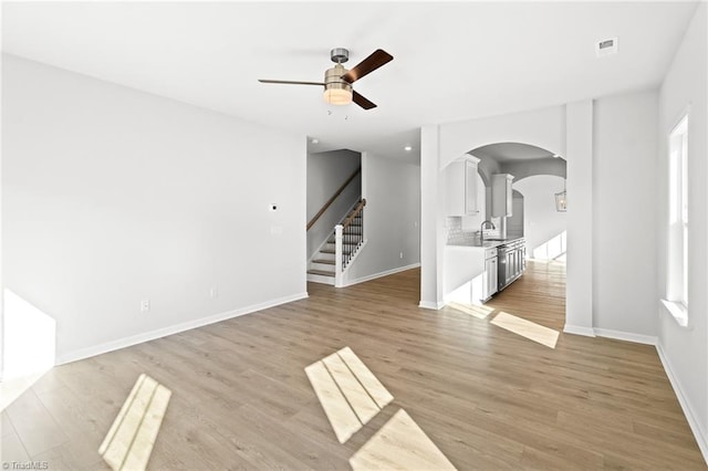 unfurnished room featuring sink, light hardwood / wood-style floors, and ceiling fan