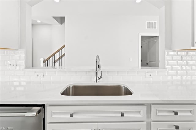 kitchen with sink, stainless steel dishwasher, and white cabinets