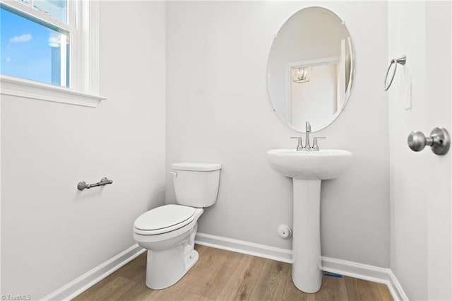 bathroom featuring wood-type flooring and toilet