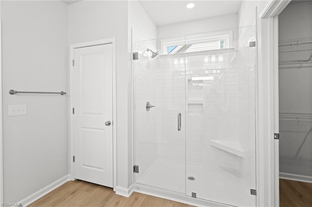 bathroom with wood-type flooring and a shower with shower door