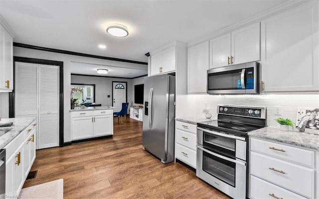 1449 NC Highway 150 W, Summerfield, NC 27358 - kitchen with stainless steel appliances, white cabinetry, decorative backsplash, wood finished floors, and ornamental molding