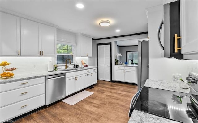 1449 NC Highway 150 W, Summerfield, NC 27358 - kitchen with stainless steel appliances, tasteful backsplash, white cabinets, light wood-style flooring, and crown molding