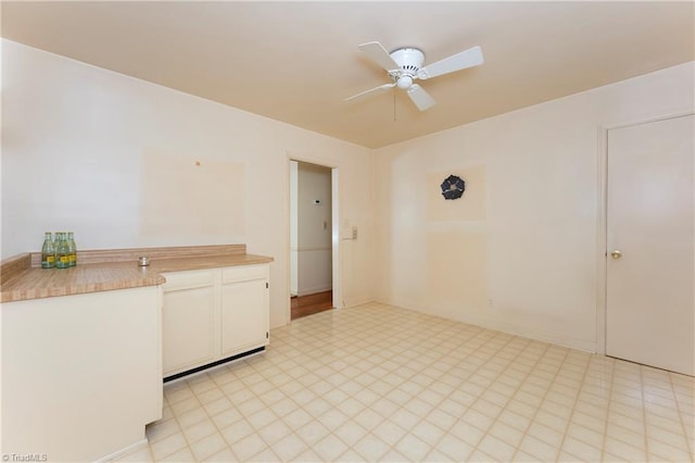 interior space with light floors and ceiling fan