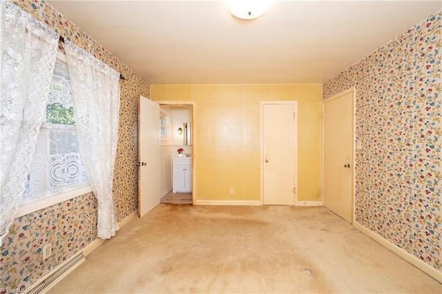 carpeted spare room featuring wallpapered walls, baseboards, and visible vents