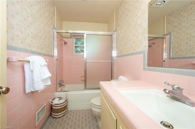 full bath featuring visible vents, wainscoting, wallpapered walls, and tile walls