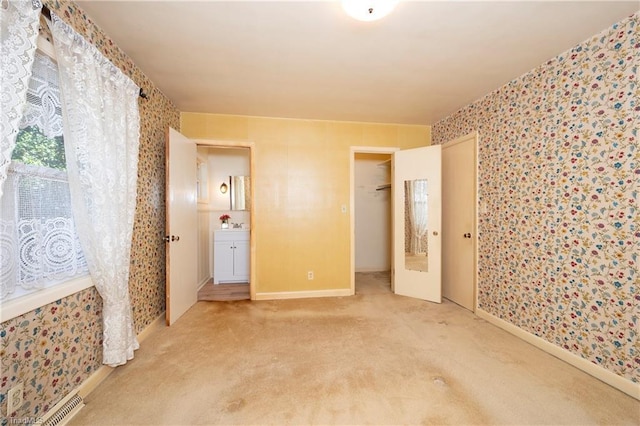 empty room with baseboards, wallpapered walls, and carpet