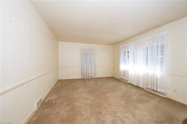 unfurnished room with visible vents and carpet