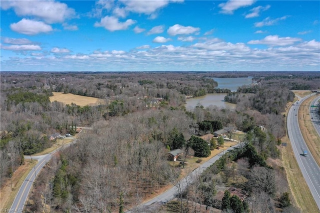 aerial view with a wooded view and a water view