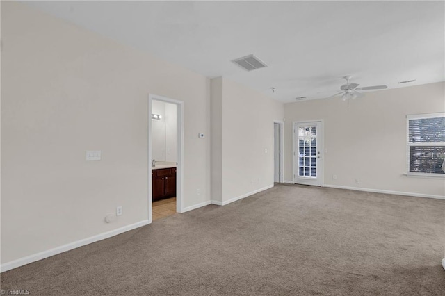 unfurnished room with ceiling fan, light carpet, and a wealth of natural light