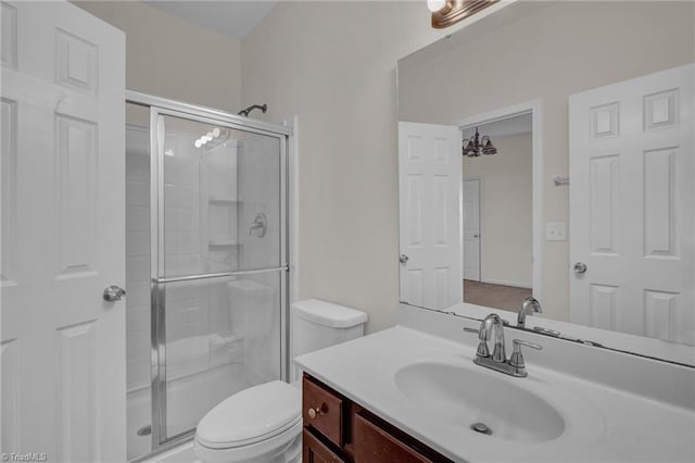 bathroom with walk in shower, vanity, and toilet