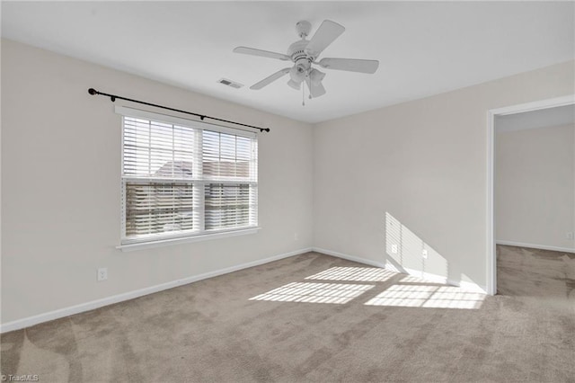 unfurnished room featuring ceiling fan and light carpet