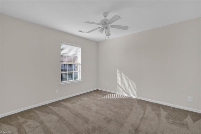 spare room featuring light carpet and ceiling fan