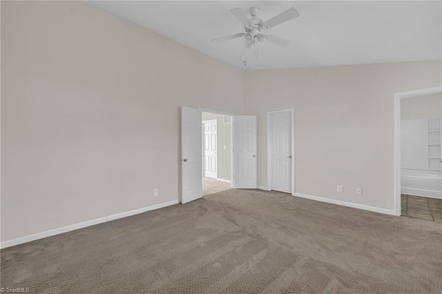 carpeted spare room with vaulted ceiling and ceiling fan