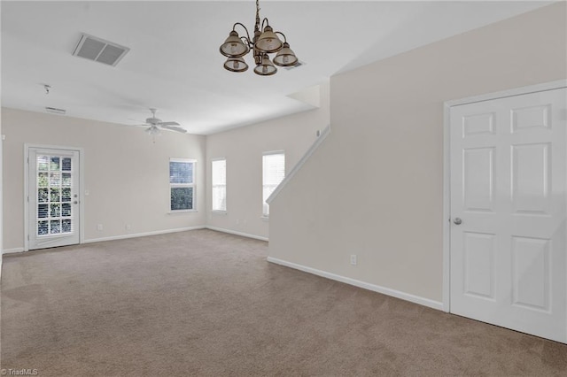 unfurnished living room with light carpet, ceiling fan with notable chandelier, and a wealth of natural light