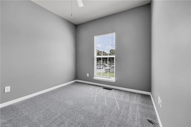 empty room featuring baseboards, ceiling fan, visible vents, and carpet floors