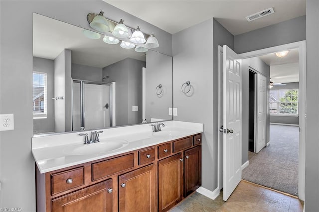 full bathroom featuring a sink, double vanity, an enclosed shower, and visible vents