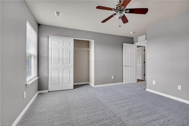 unfurnished bedroom featuring carpet flooring, multiple windows, and visible vents
