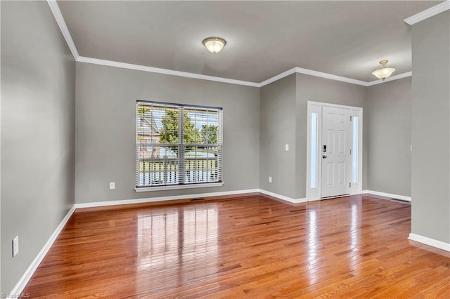 entrance foyer featuring baseboards, ornamental molding, and wood finished floors