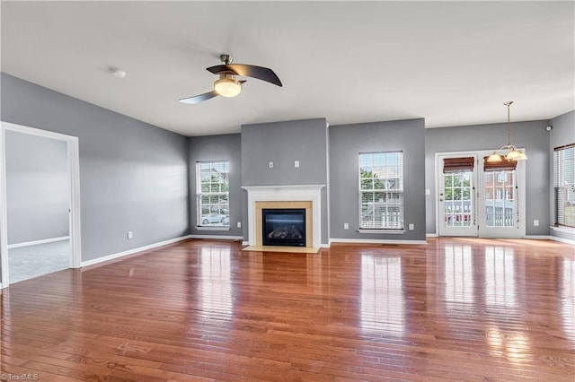 unfurnished living room with ceiling fan, plenty of natural light, and wood finished floors