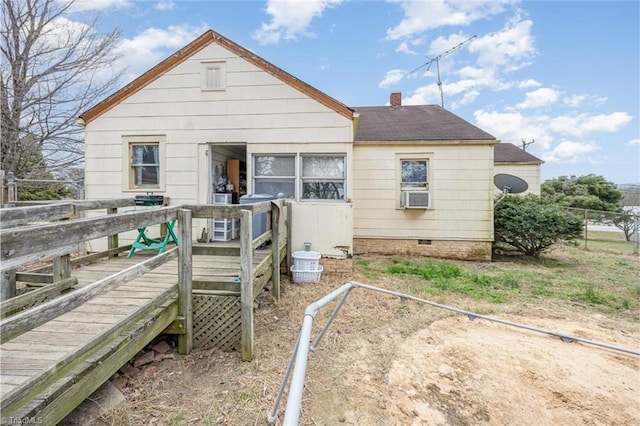 view of front of home featuring a deck, cooling unit, a chimney, and a shingled roof