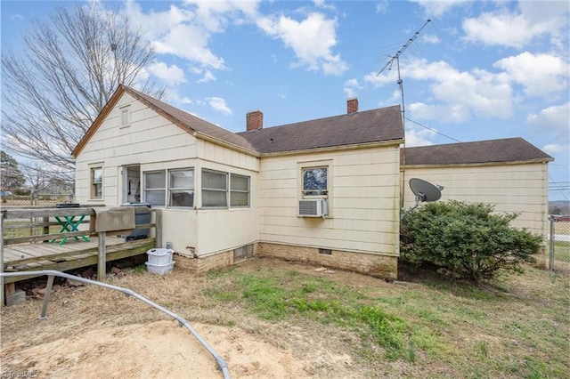 back of house featuring cooling unit, a chimney, and fence