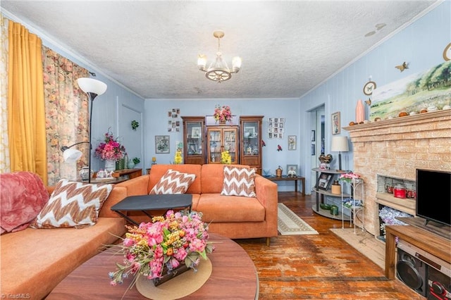 living area with a chandelier, ornamental molding, a fireplace, wood finished floors, and a textured ceiling