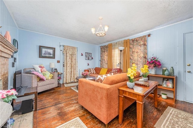 living area with a chandelier, a textured ceiling, crown molding, and wood finished floors