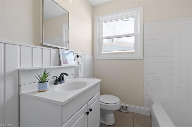 bathroom featuring vanity, a bath, and toilet