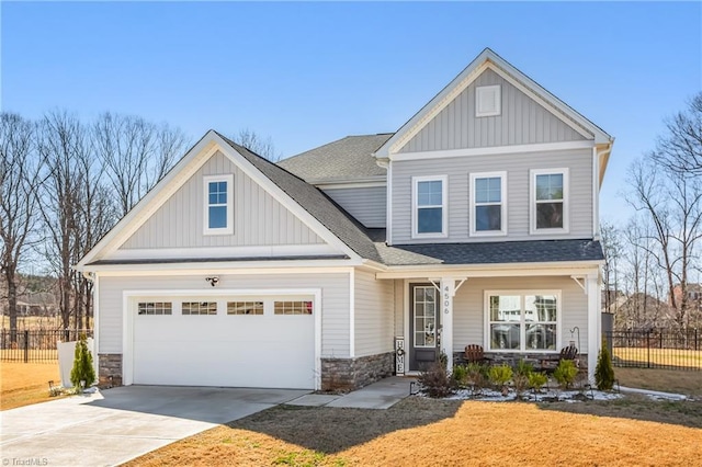 craftsman inspired home with a garage, fence, board and batten siding, and concrete driveway